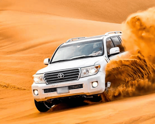 Exciting desert safari Dubai dune bashing in a Toyota Land Cruiser across the sandy desert terrain.